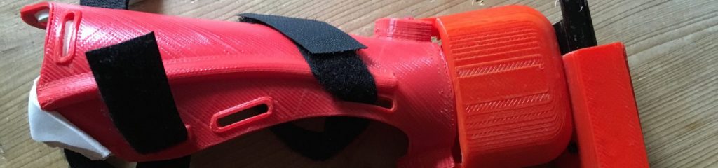 3D printed prosthetic bow holder with bow and velcro for attaching to the arm.